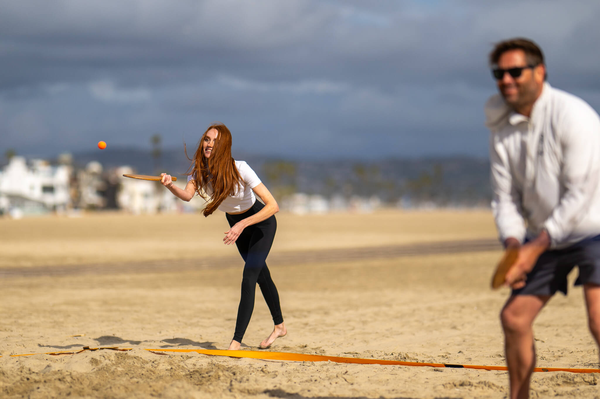 Girl hitting Vole Drop to begin Rally On doubles game