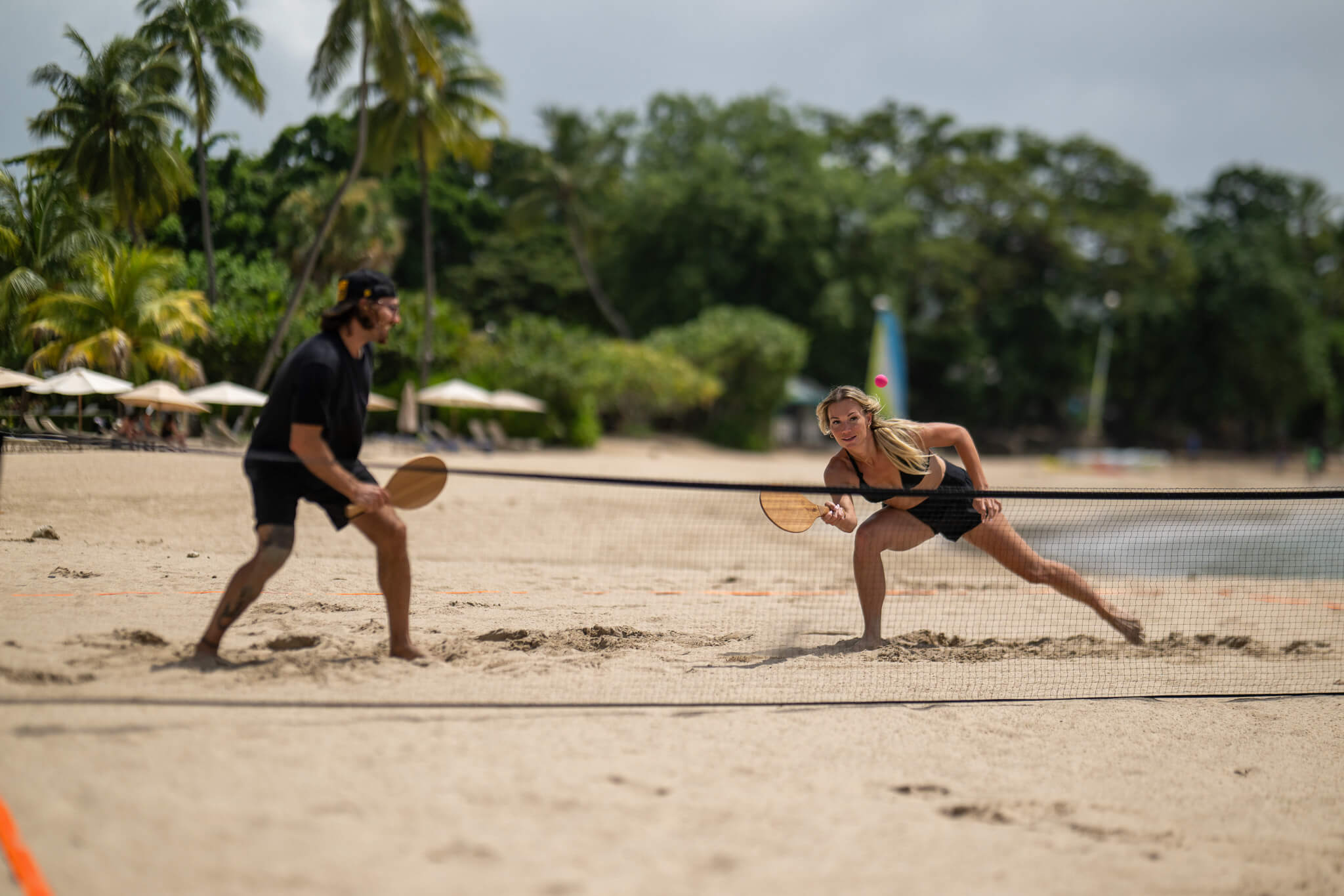 Girl hitting pink Vole Drop with Teak Vole Paddle in the Rally Court playing Doubles Rally On